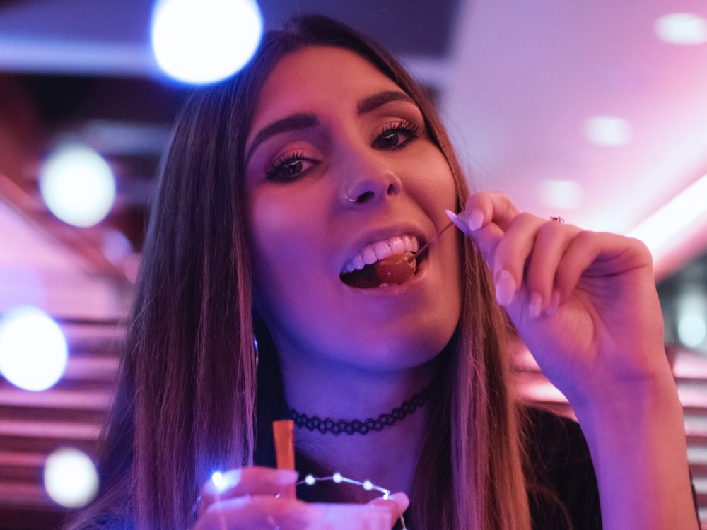 Jonge vrouw met tattoo ketting, glas en kers