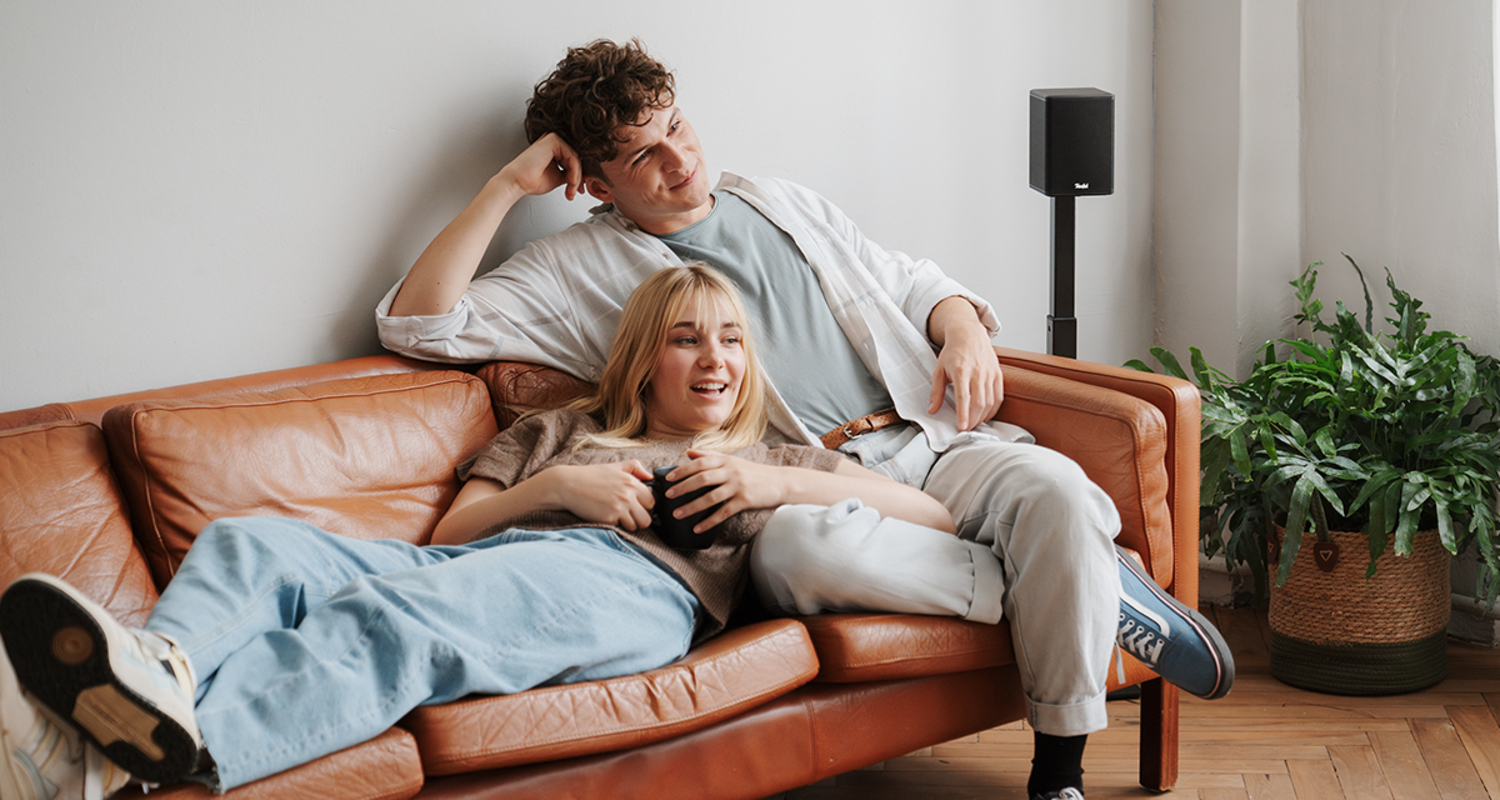 Zwei Freunde unterhalten sich im Wohnzimmer.