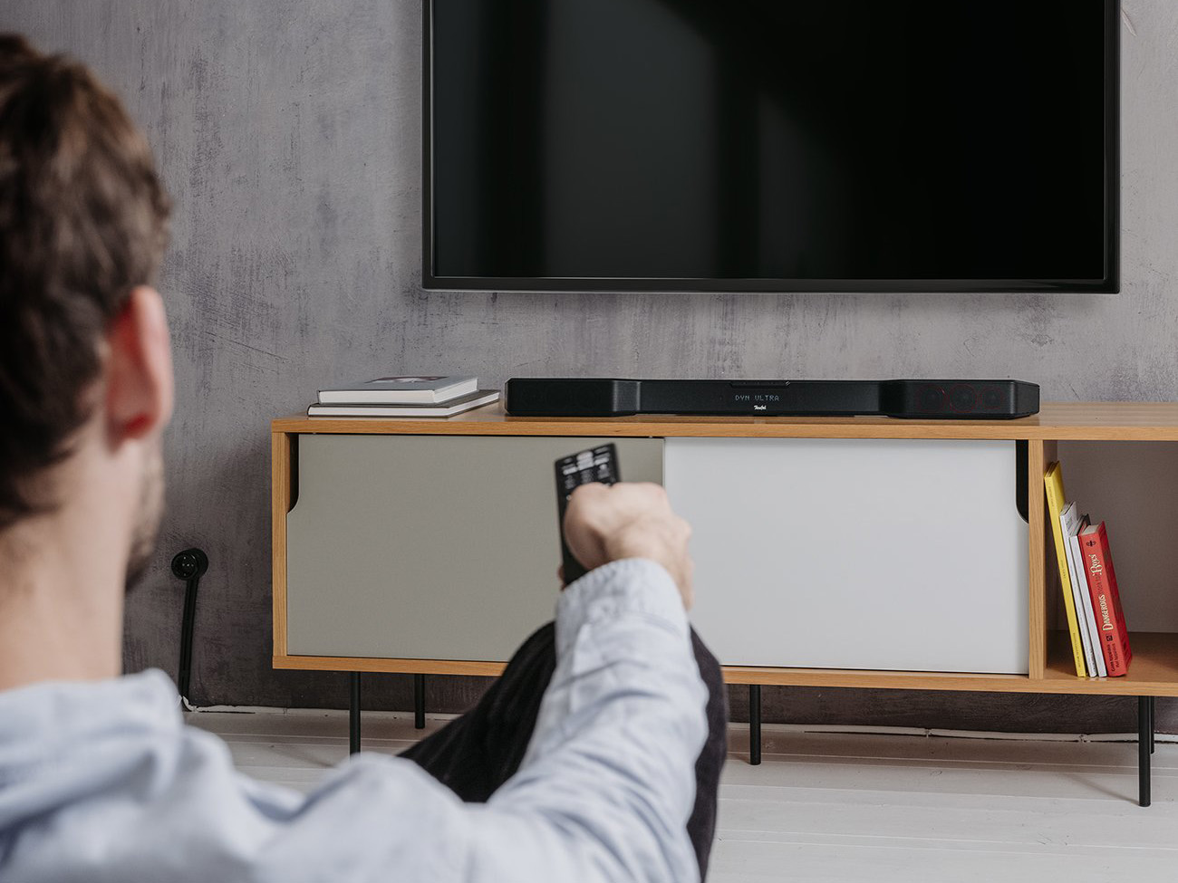 Man op de bank kijkend naar tv met soundbar