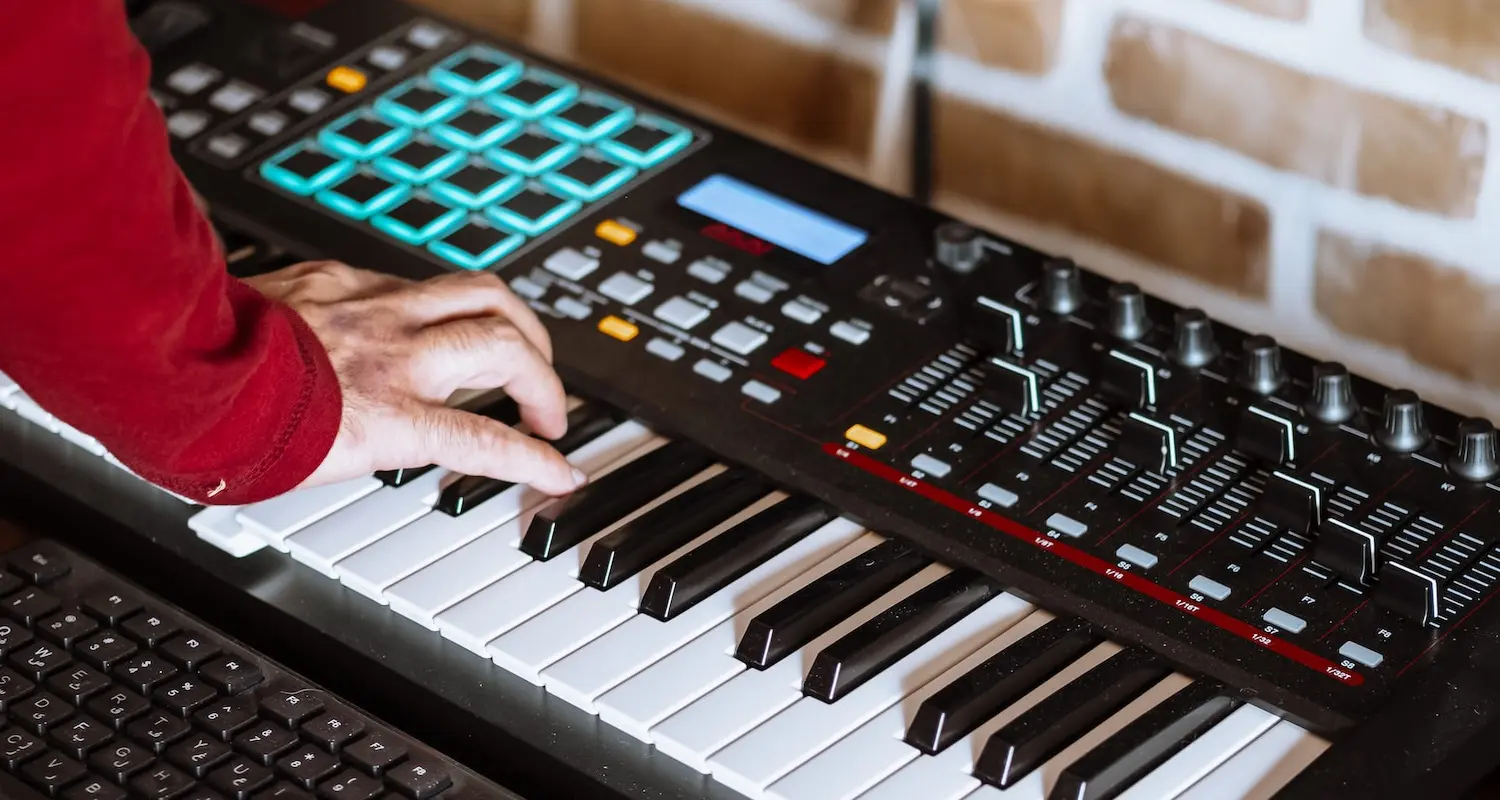 Hand spielt auf einem Synthesizer