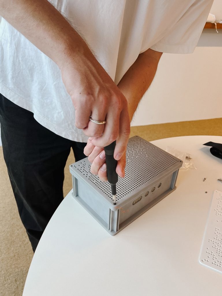 Man aan het werk bij het openschroeven van de Mynd speaker.