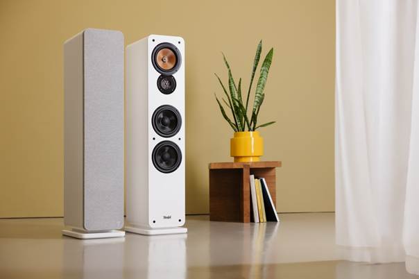 Afbeelding van een witte ULTIMA 40 MK4 stereoset tegen een woonkamerachtergrond naast een plant.